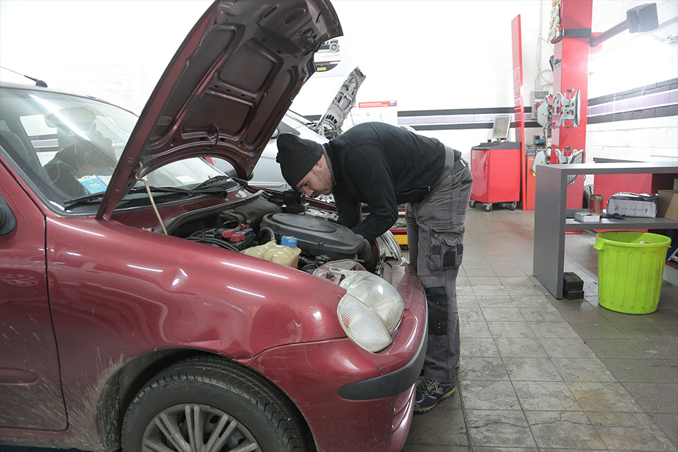 man checking car engine