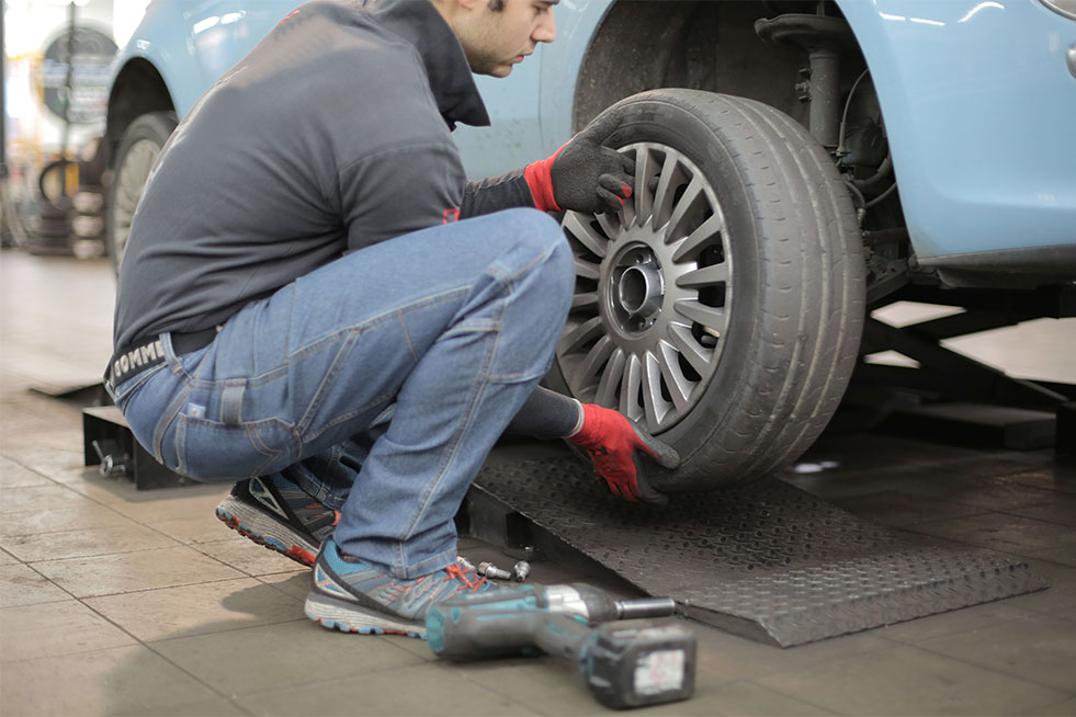 man replacing car tyre